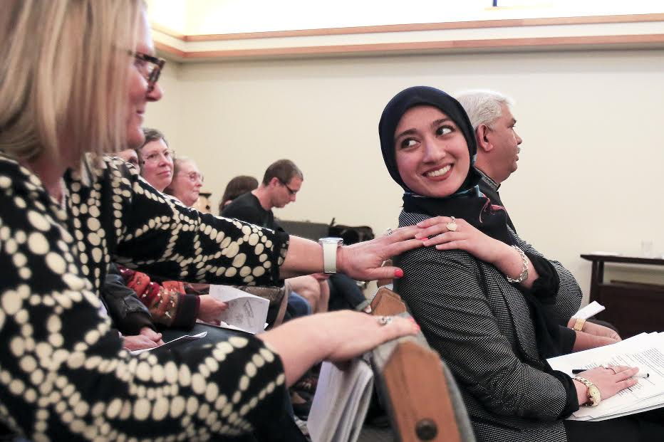 Theresa Greco (left) offers a hand after Varnish Khan’s speech at the Mukilteo meeting.