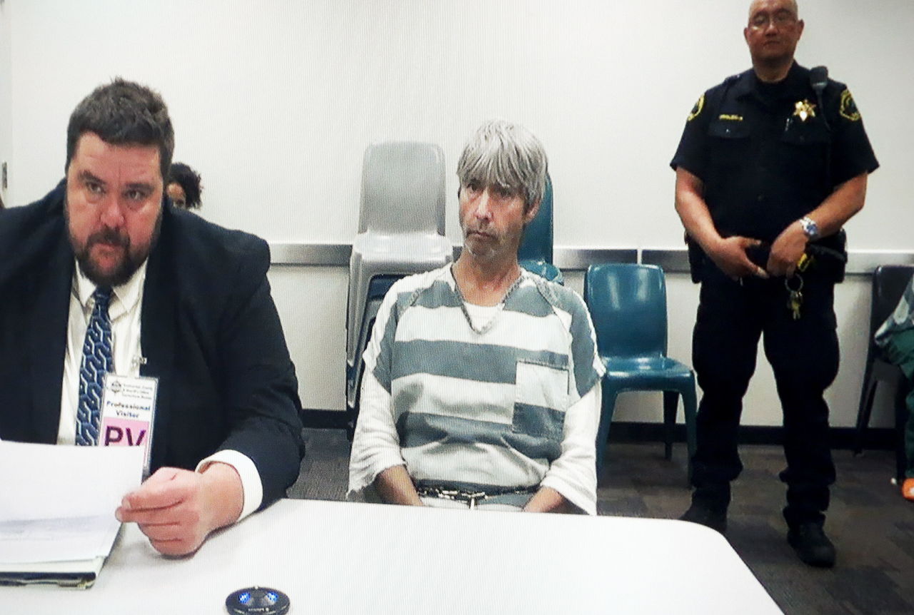 Tony Clyde Reed (center) appears on a monitor during his arraignment on two counts of first-degree murder and unlawful gun possession on Tuesday at Snohomish County Courthouse in Everett. Reed was apprehended in San Diego on May 16 and is charged in connection with the alleged murder of Oso’s Patrick Shunn and his wife, Monique Patenaude.