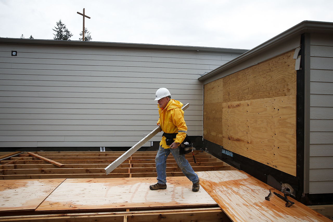 Daryl Daugs moves equipment while building a new 3,000-square-foot structure to be used for a preschool at Our Saviour’s Lutheran Church in Arlington on Thursday. Daugs and other volunteers are helping the church with their project as part of the Mission Builders program.