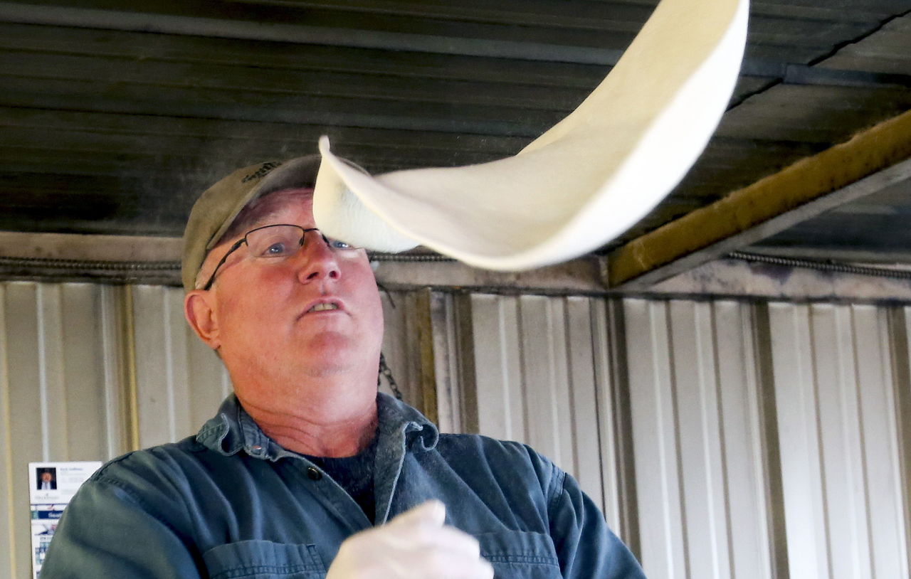 Norm Thomson preps dough for a pizza at his truck in Machias on May 22.