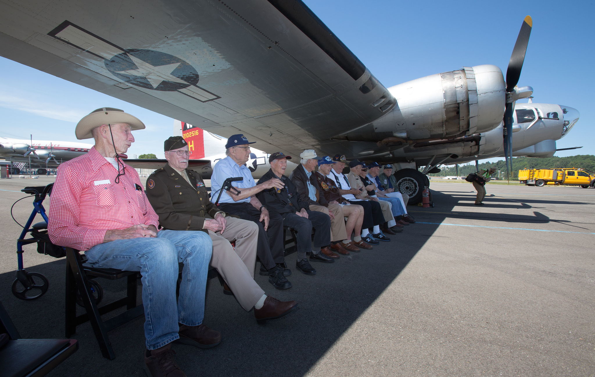 A dozen B-17 bomber veterans sit under the Aluminum Overcast’s wing.