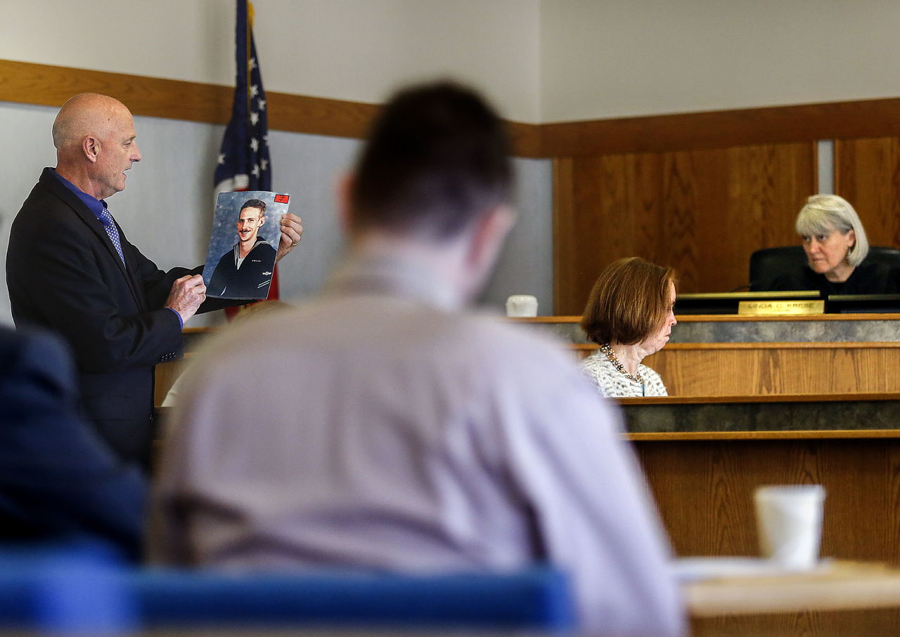 Prosecutor Mark Roe (left) brings out a photo of murder victim Blair Scott early Tuesday at the Snohomish County Courthouse, to emphasize before Superior Court Judge Linda Krese (far right) that Scott and his family still matter in the court’s decision regarding parole eligibility for convicted murderer Michael Skay (foreground).