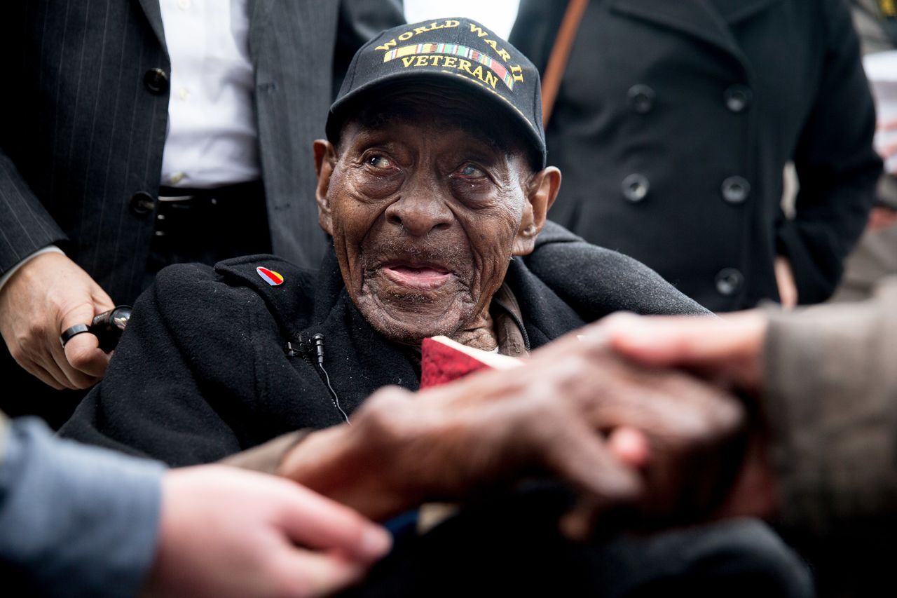 In this Dec. 7, 2015, photo, Frank Levingston Jr., of Lake Charles, Louisiana, is greeted by visitors following a wreath laying ceremony to mark the anniversary of Pearl Harbor at the World War II Memorial in Washington. Levingston, a 110-year-old veteran who served in World War II, died Tuesday.