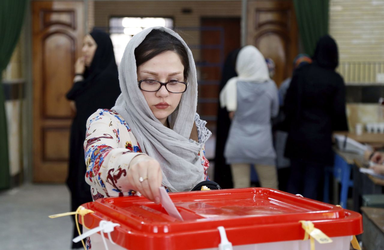 An Iranian woman casts her ballot Friday in Qods, about 12 miles west of the capital, Tehran.