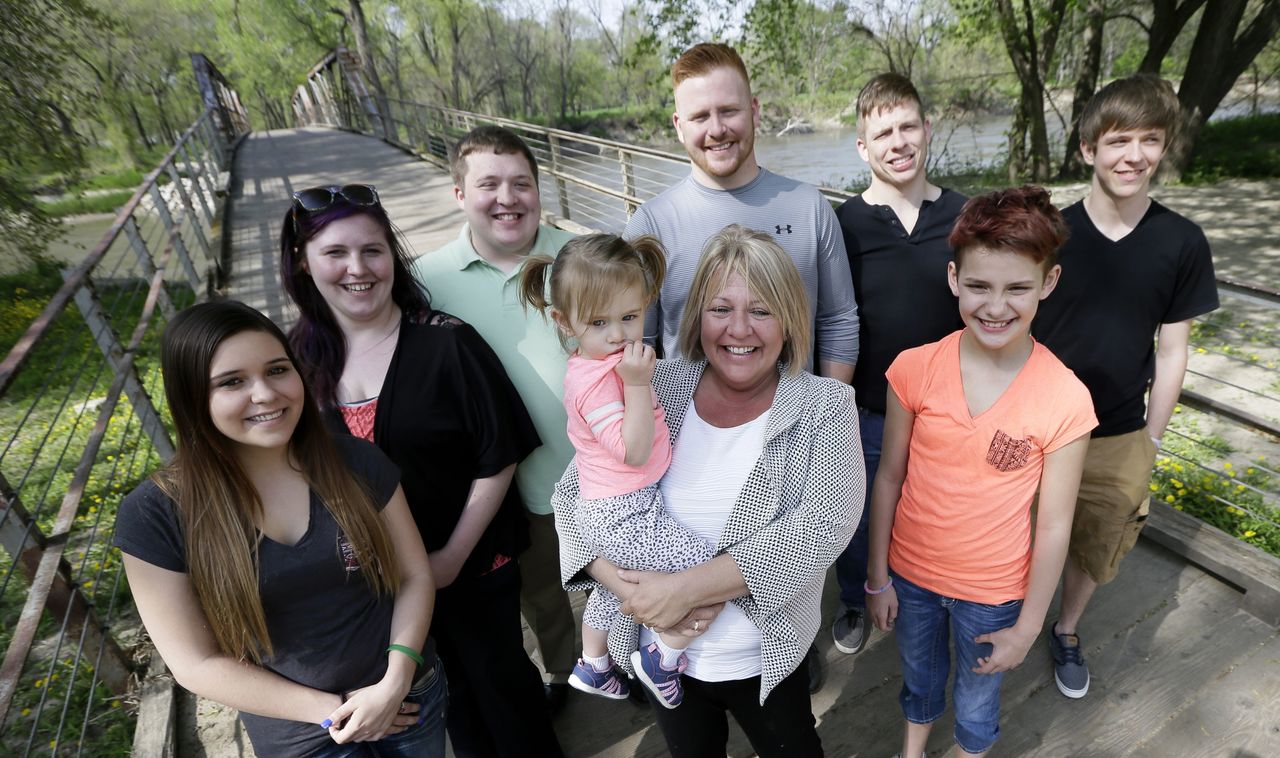 Denise Moore (center in white), of Des Moines, Iowa, poses with her family Tuesday during a visit to Water Works Park in Des Moines, Iowa. Moore, a mother of seven, nearly lost her parental rights after her arrest in 2003 for conspiracy to deliver methamphetamine.