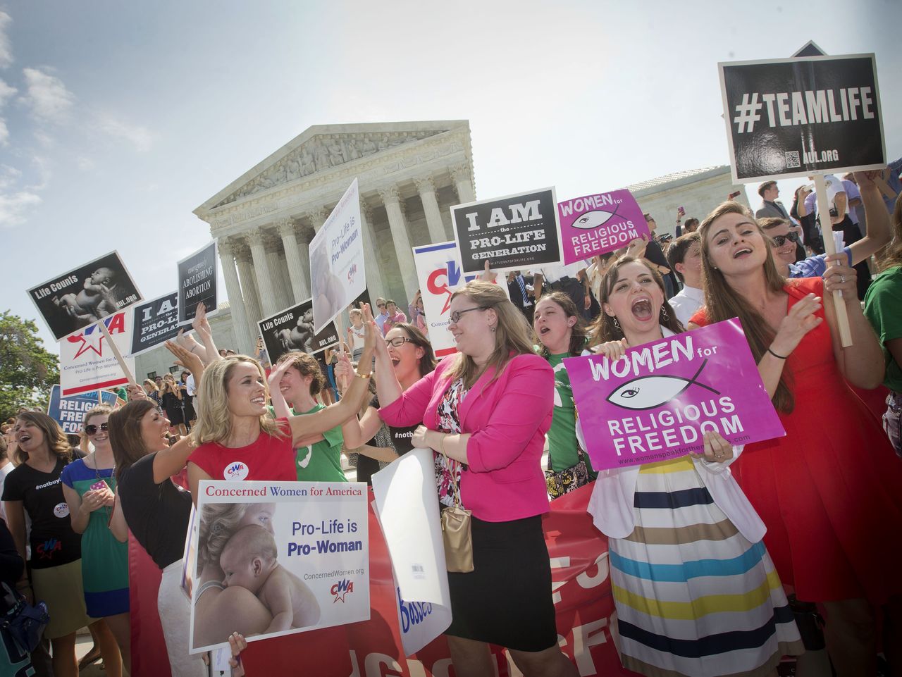 In this June 30, 2014, photo, demonstrators react to hearing the Supreme Court’s decision on the Hobby Lobby birth control case outside the Supreme Court in Washington. The Supreme Court rid itself Monday of a knotty dispute between faith-based groups and the Obama administration over birth control. The court asked lower courts to take another look at the issue in a search for a compromise.