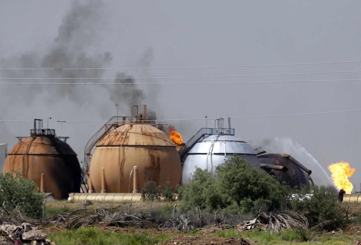 Iraqi firefighters try to extinguish a fire at a natural gas plant in Taji, Iraq, on Sunday.