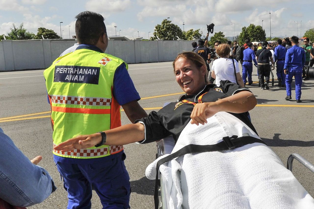 Marta Miguel is stretchered away upon her arrival at the Kota Kinabalu International Airport in Sabah, Malaysia, on Friday. Miguel was among the four who were rescued after their boat capsized off the northern coast of the island of Borneo.