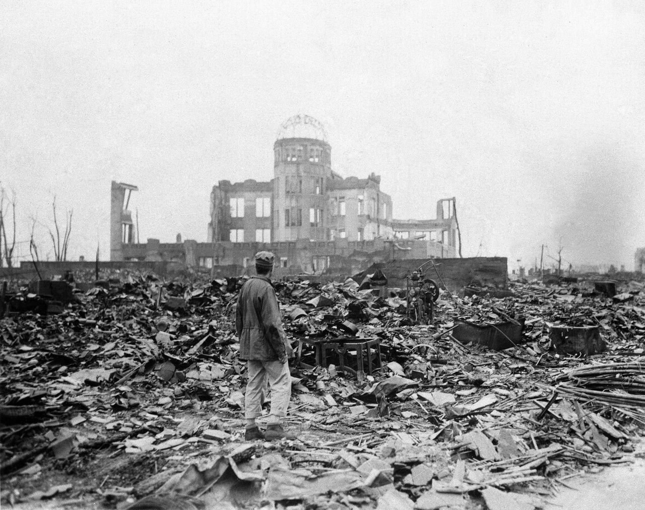 This Sept. 8, 1945, picture shows an allied correspondent standing in the rubble in front of the shell of a building that once was a movie theater in Hiroshima, Japan, a month after the first atomic bomb ever used in warfare was dropped by the U.S.