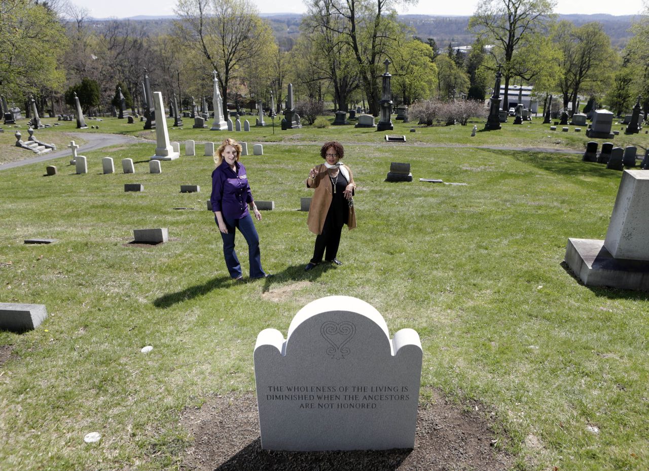 Kelly Grimaldi (left), historian at St. Agnes Cemetery, and Evelyn Kamili King, project manager for Schuyler Flatts Burial Ground Project, stand at a plot where 14 slaves will be reburied in Menands, New York.