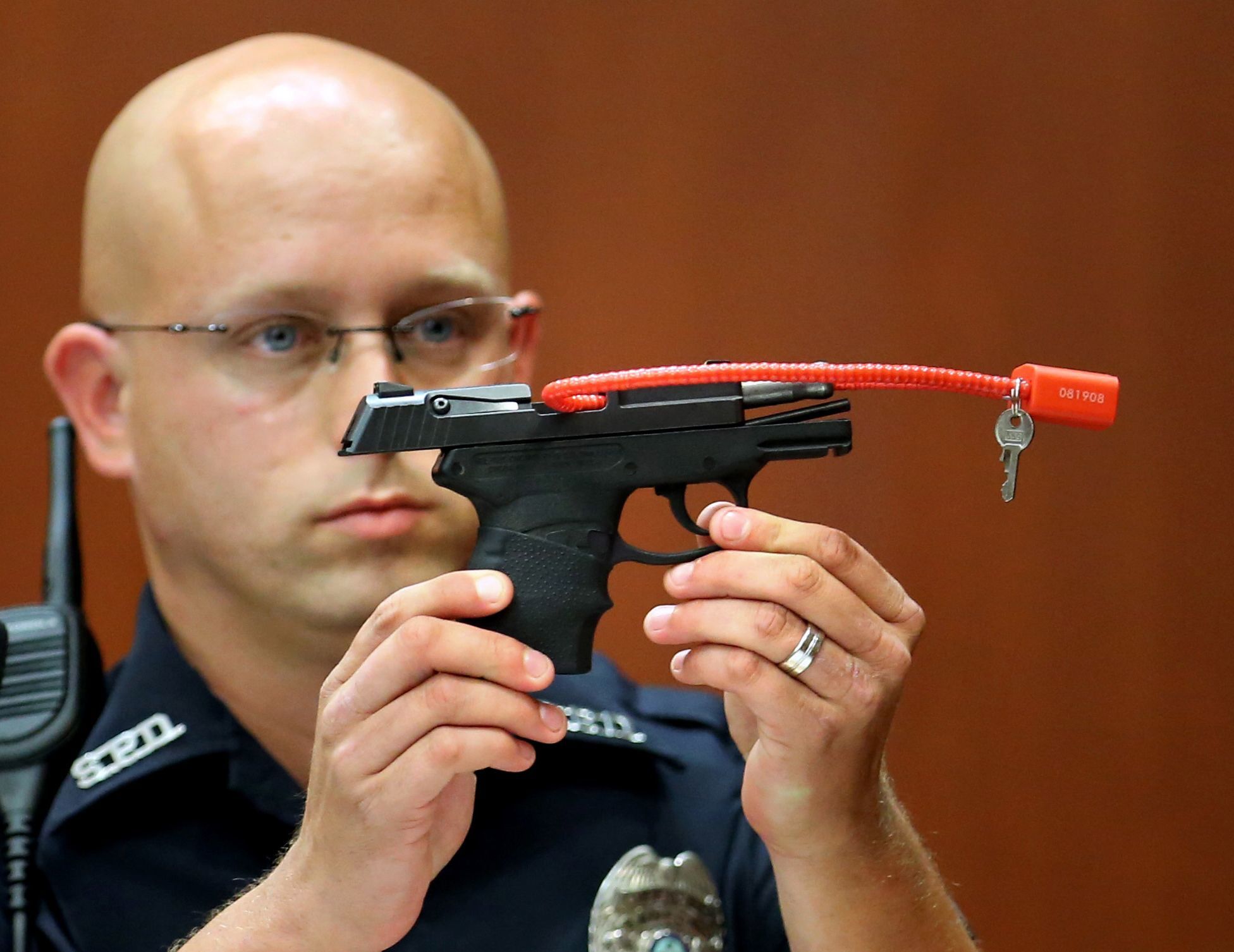 In this June 28, 2013, photo, Sanford police officer Timothy Smith holds up the gun that was used to kill Trayvon Martin.