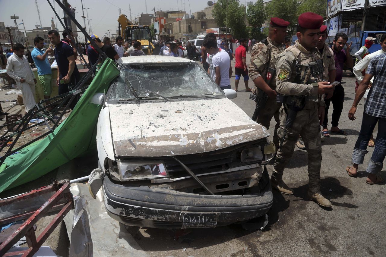 Security forces and citizens inspect the scene after a car bomb explosion at a crowded outdoor market in the Iraqi capital’s eastern district of Sadr City, Iraq, on Wednesday.