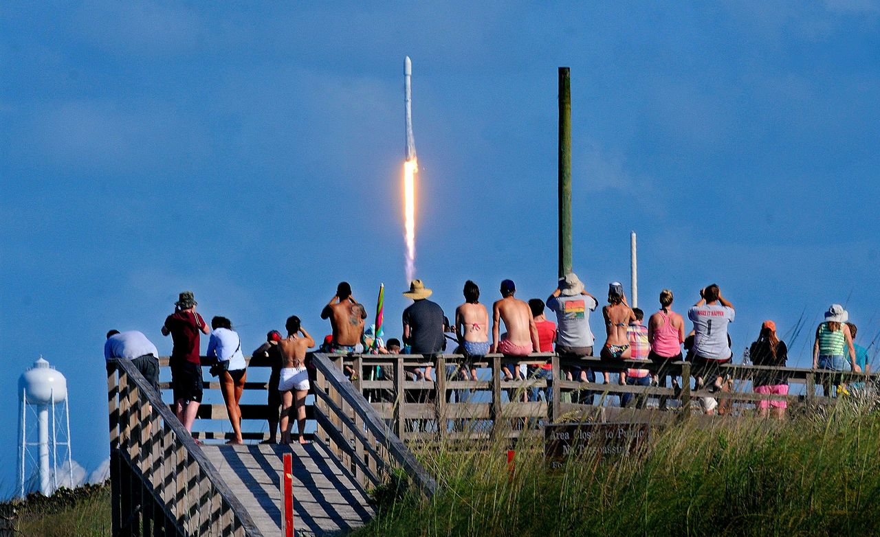 Crowds pack the Canaveral National Seashore on Friday to watch the liftoff of a SpaceX Falcon 9 rocket at the Cape Canaveral Air Force Station.