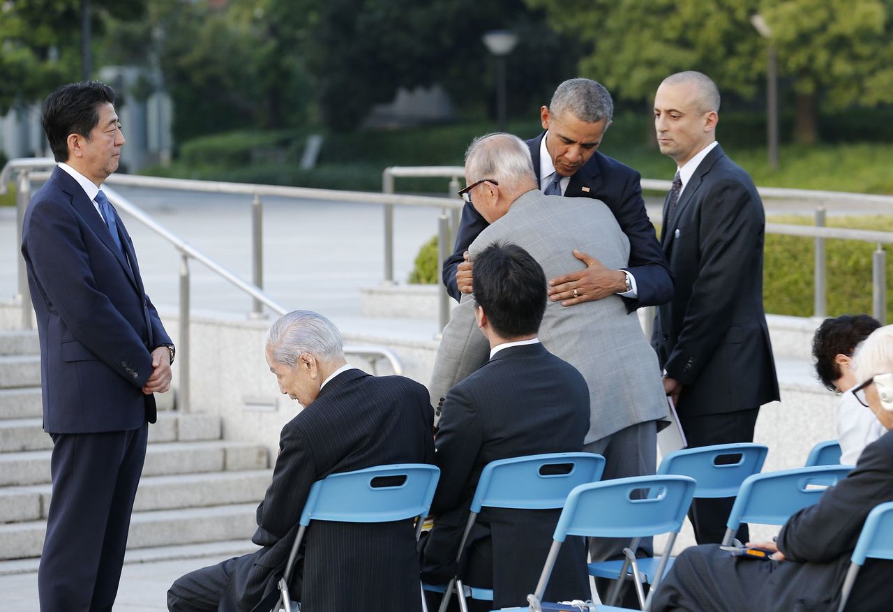 U.S. President Barack Obama hugs Shigeaki Mori, an atomic bomb survivor and a creator of the memorial for American WWII POWs killed in Hiroshima, as Japanese Prime Minister Shinzo Abe, left, watches them during a ceremony at Hiroshima Peace Memorial Park in Hiroshima, western, Japan, on Friday.