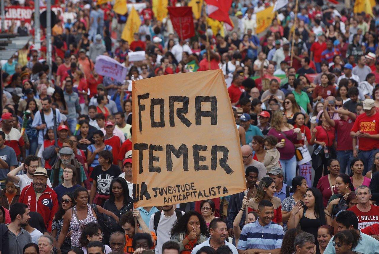 With a sign that reads in Portuguese “Temer out,” demonstrators march against Brazil’s acting President Michel Temer and in support of Brazil’s suspended President Dilma Rousseff, in Sao Paulo, Brazil, on Sunday. Temer took office after Rousseff was suspended for up to 180 days while the Senate holds an impeachment trial.
