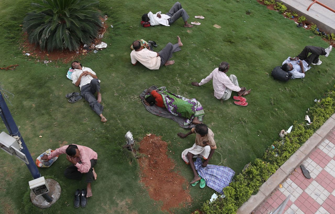 Indians rest under the shade of a tree on a hot summer afternoon in Hyderabad, India, on Friday.