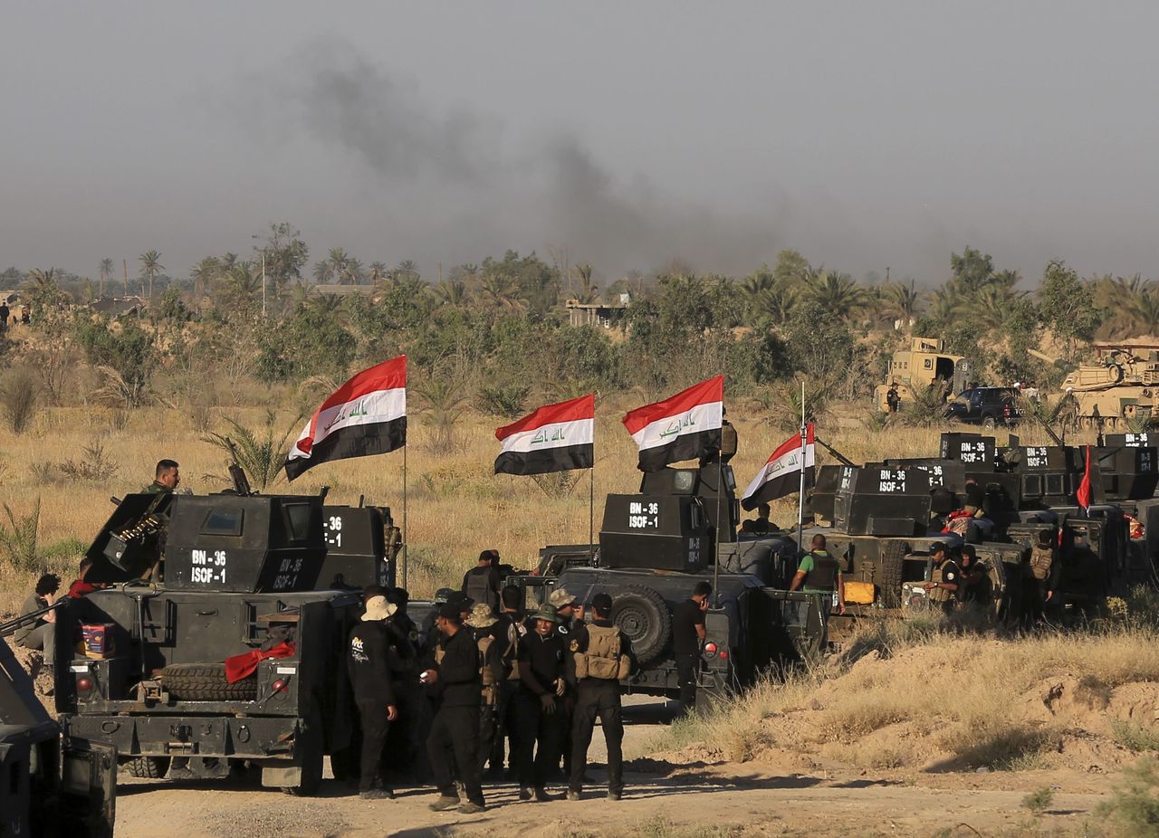 Smoke billows on the horizon as Iraqi military forces prepare for an offensive into Fallujah to retake the city from Islamic State militants in Iraq on Monday. A wave of bombings claimed by the Islamic State group targeted commercial areas in and around Baghdad on Monday, killing more than 20 people in attacks that came as Iraqi troops poised to recapture Fallujah.