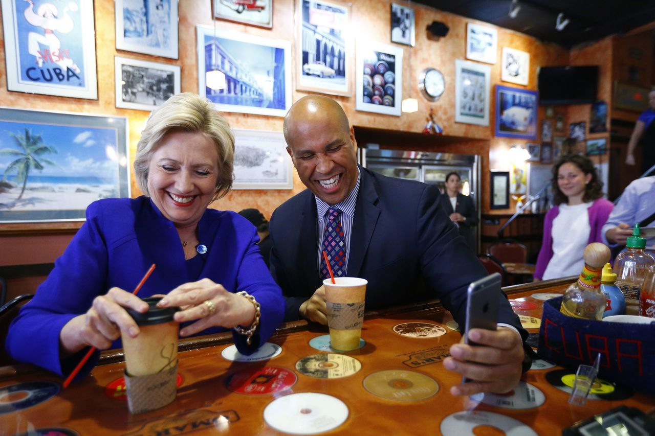 Democratic presidential candidate Hillary Clinton talks with Sen. Cory Booker at Omar’s Cafe while campaigning Wednesday in Newark, New Jersey.