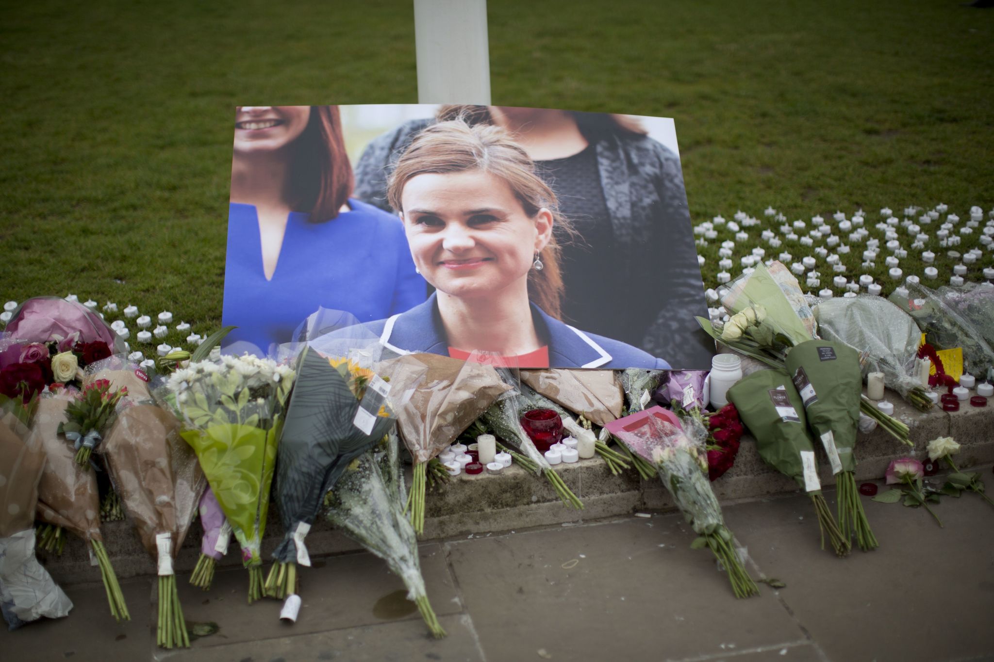 An image and floral tributes for Jo Cox, the 41-year-old British Member of Parliament shot to death yesterday in England, lie outside the House of Parliament in London on Friday.