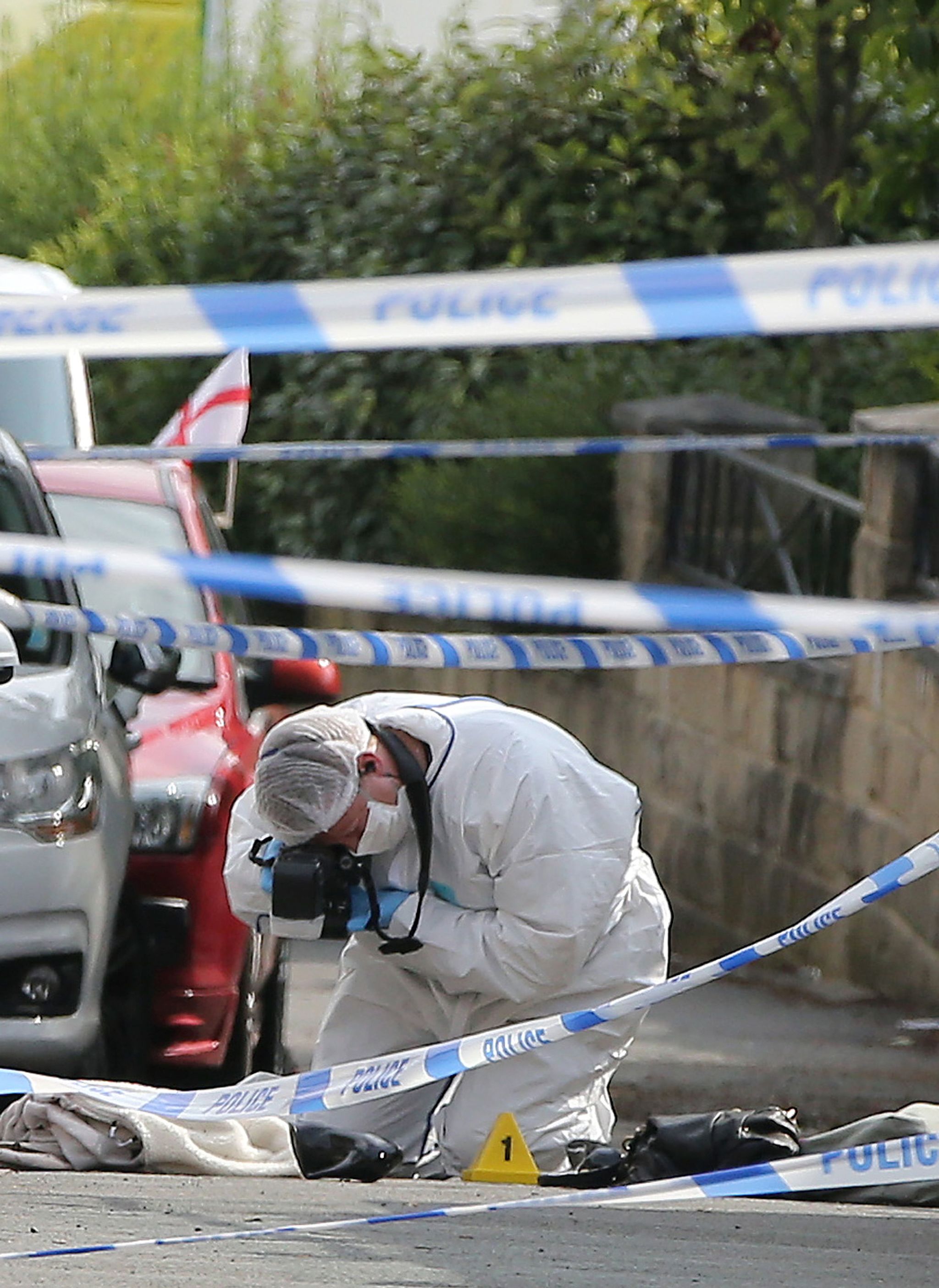 A forensics officer takes photos of a female’s shoe at the scene after Labour MP Jo Cox was shot and stabbed in an attack in her constituency, in Birstall, West Yorkshire, England, on Thursday.