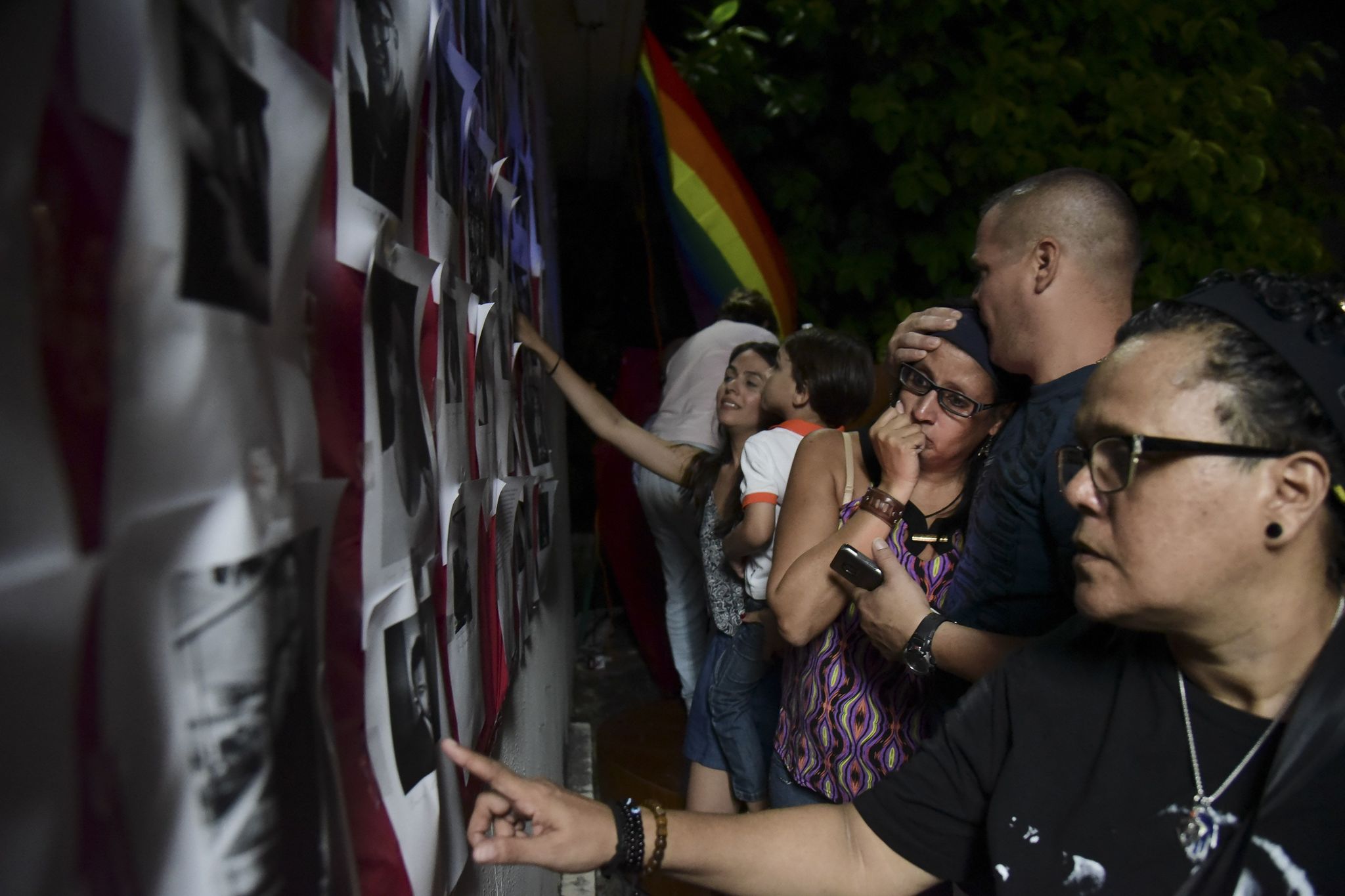 Residents look at photos of the victims during a vigil to honor the memory of the Puerto Ricans who died in the mass shooting at a nightclub in Orlando, Florida, at the Hato Rey LGBTT Community Center in San Juan, Puerto Rico, on Tuesday.