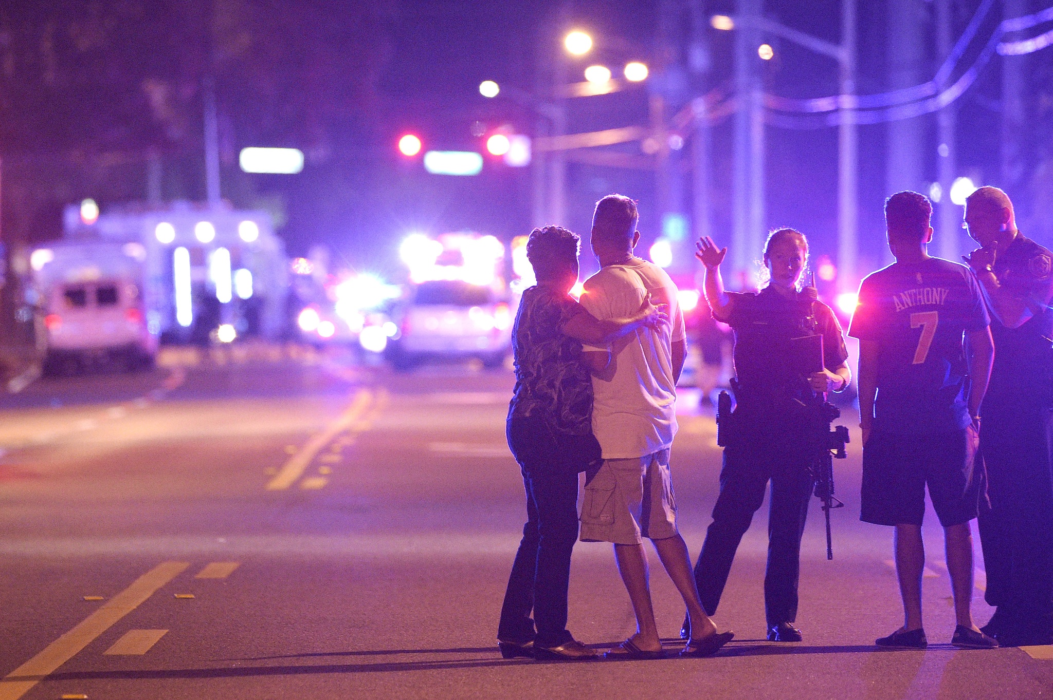 Orlando police officers direct family members away from a fatal shooting at Pulse Orlando nightclub Sunday.