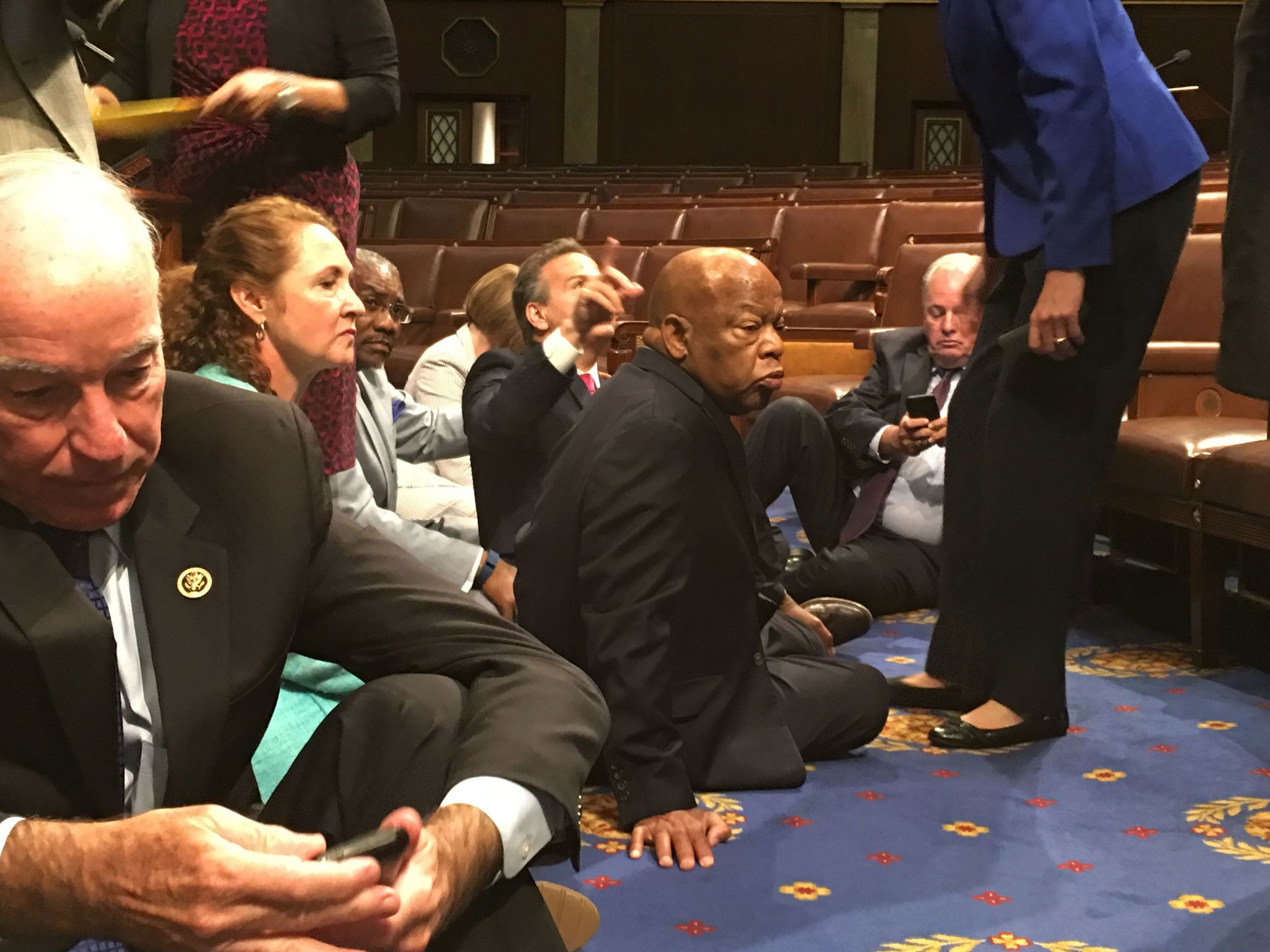 Democrats in Congress, including Rep. John Lewis, D-Ga. (center), and Rep. Joe Courtney, D-Conn. (left), take part in a sit-in protest seeking a vote on gun control measures Wednesday on the floor of the House in Washington.