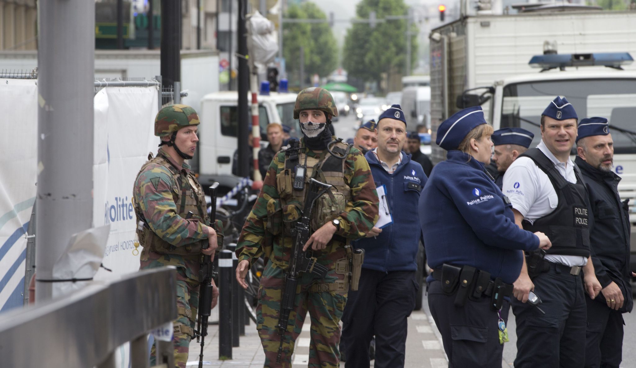 Belgian police and Belgian Army soldier stand guard at the scene of a bomb alert on a major shopping street in Brussels on Tuesday. Belgian authorities took a man into custody early Tuesday following a pre-dawn security alert at a major shopping center in downtown Brussels.