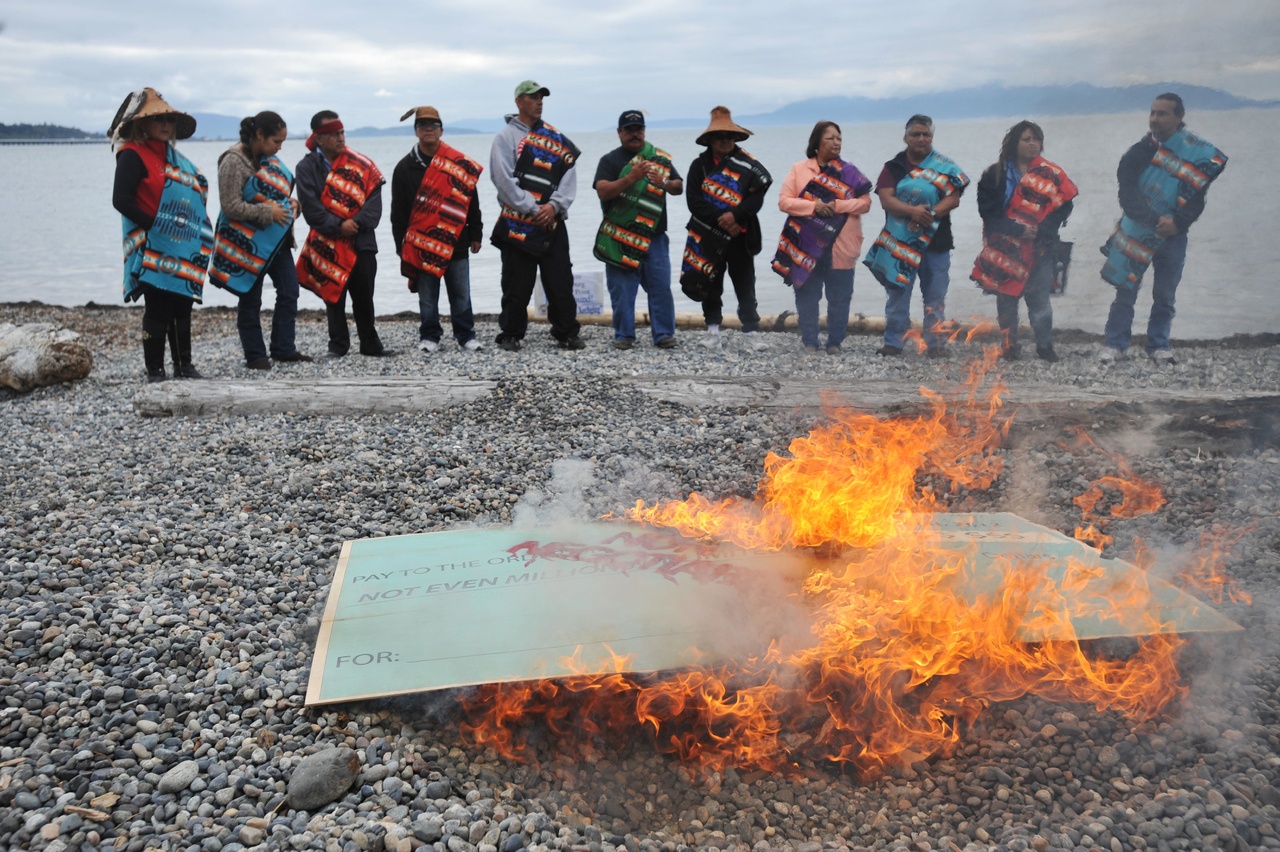In 2012, members of the Lummi Nation protest the proposed coal export terminal at Cherry Point near Bellingham by burning a large check stamped "Non-Negotiable."