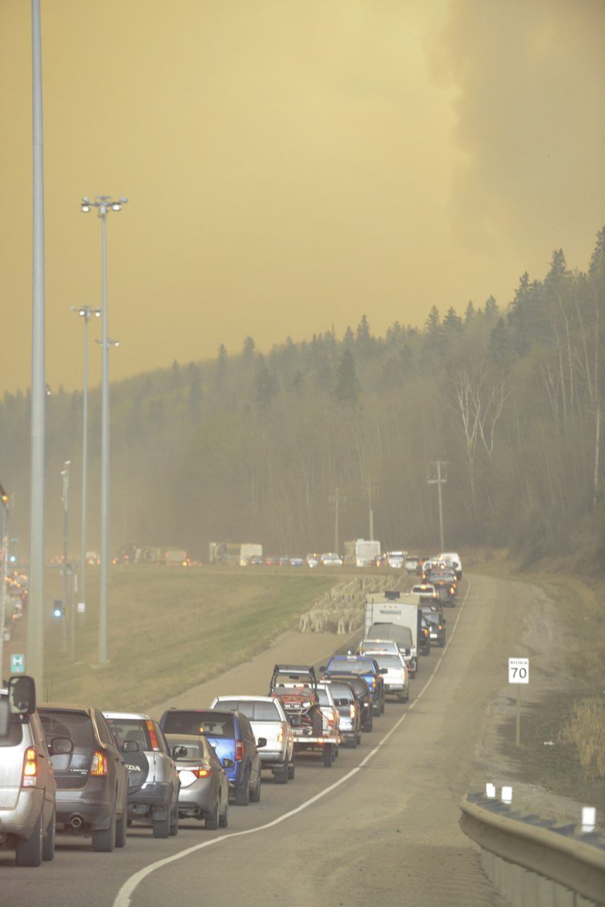 Smoke fills the air as people drive on a road in Fort Mcmurray, Alberta, on Tuesday.