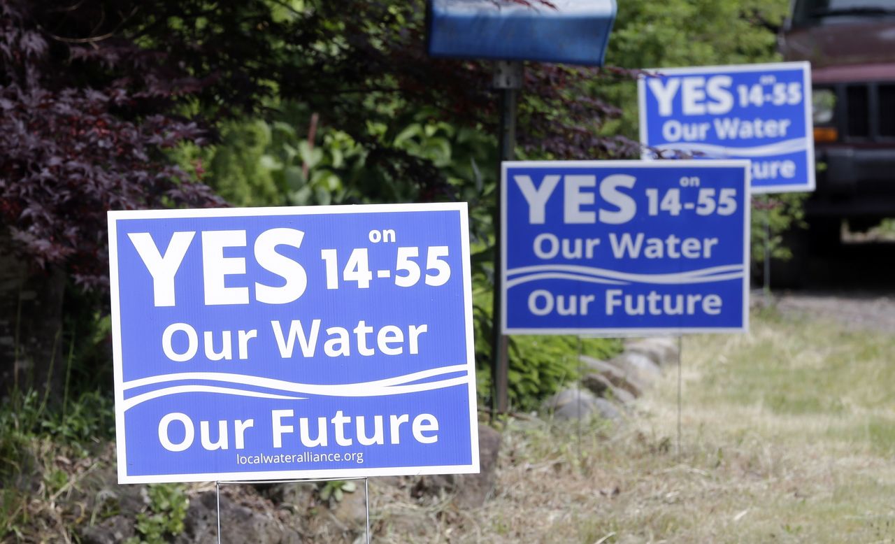 Yard signs regarding the issue of a Nestle spring water bottling plant are shown in Cascade Locks, Oregon.