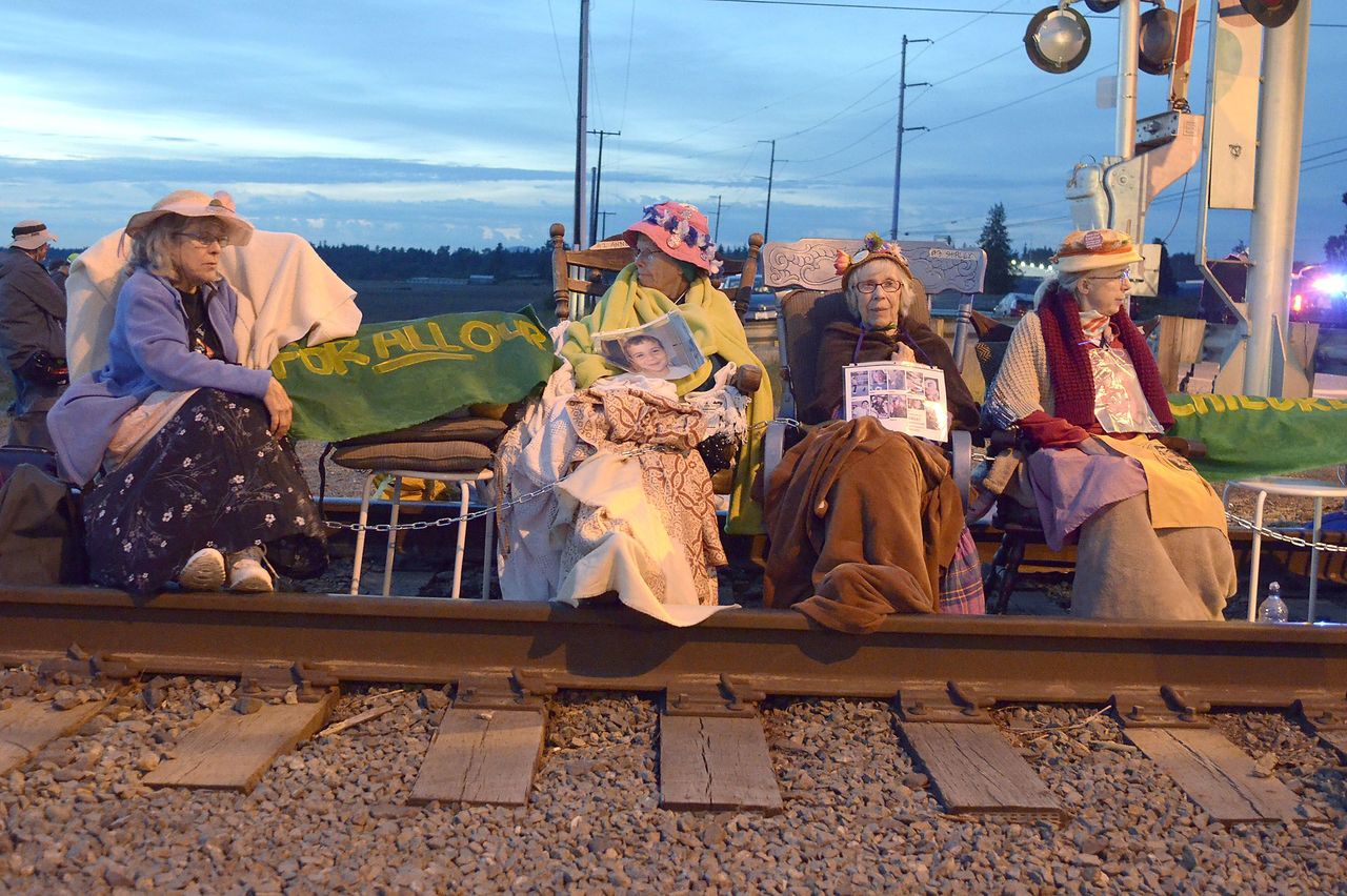Members of the Seattle Raging Grannies sit in their rocking chairs chained together on the Burlington-Northern Railroad tracks at Farm to Market Road on Friday in Burlington. From left are Deejay Sherman Peterson, Anne Thureson, Shirley Morrison and Rosy Betz-Zall.