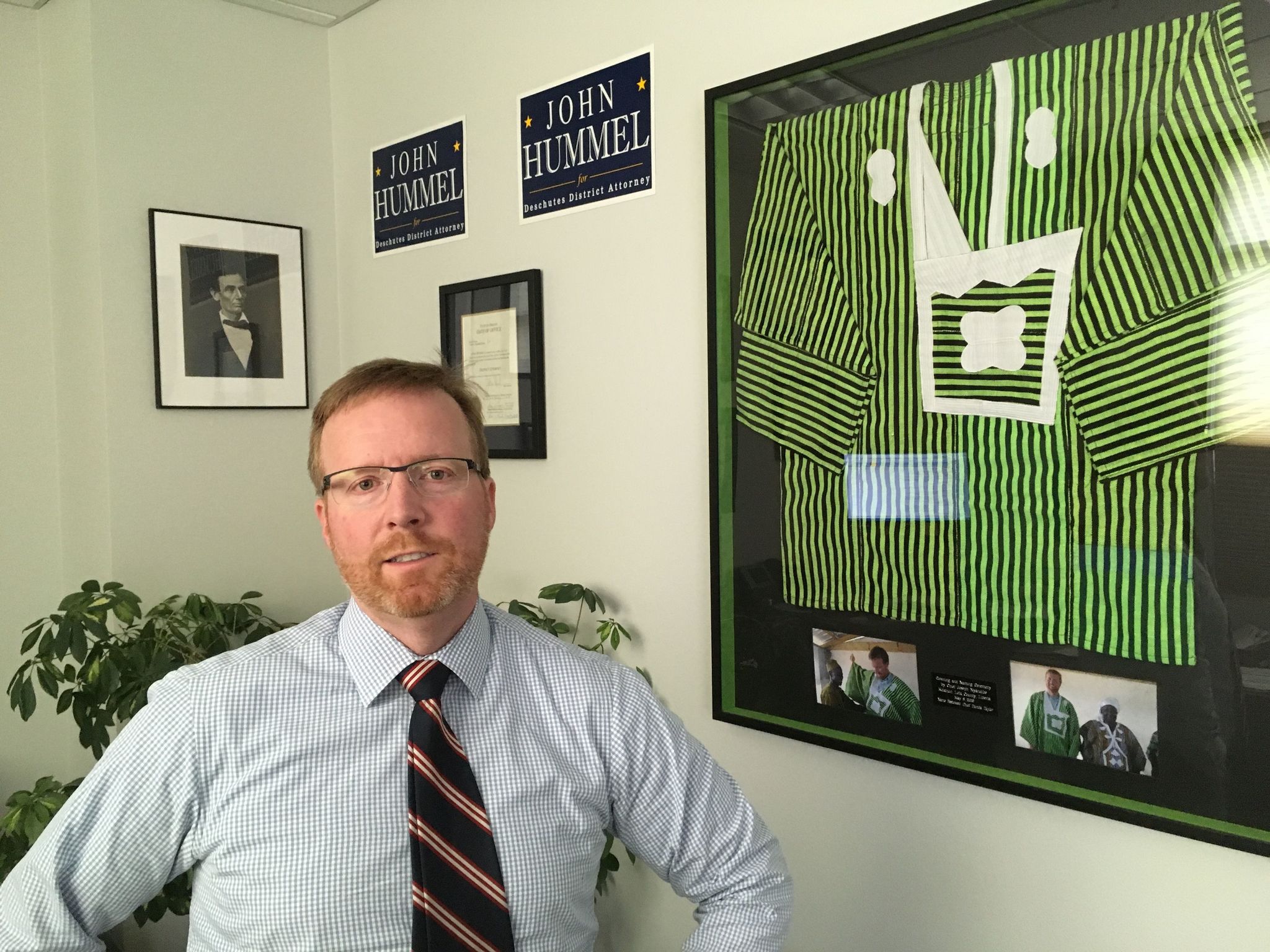 Deschutes County District Attorney John Hummel stands in his Bend, Oregon, office May 15 next to a gown he received in 2009 while working for the Carter Center in Liberia. Hummel, who is examining about 1,500 convictions after a state police forensics lab technician allegedly tampered with evidence, says his experiences in the West African country helps guide him.