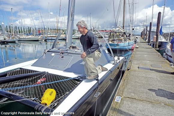 Brandon Davis, of Turn Point Design, inspects the 24-foot carbon catamaran that will compete in this year’s Race to Alaska. The boat was the first local entry for the 2015 race but turned back due to too much rudder strain in high winds.