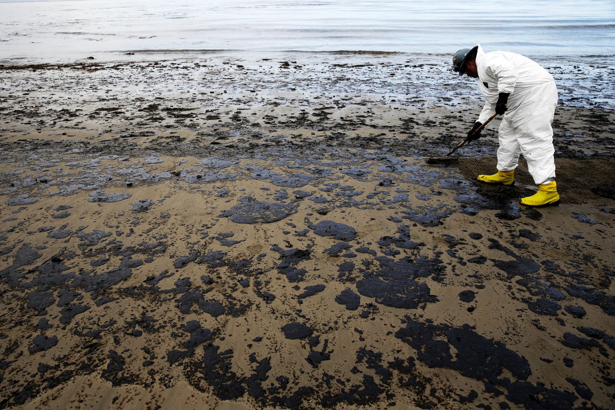 A worker removes oil from sand at Refugio State Beach, north of Goleta, California, in 2015.