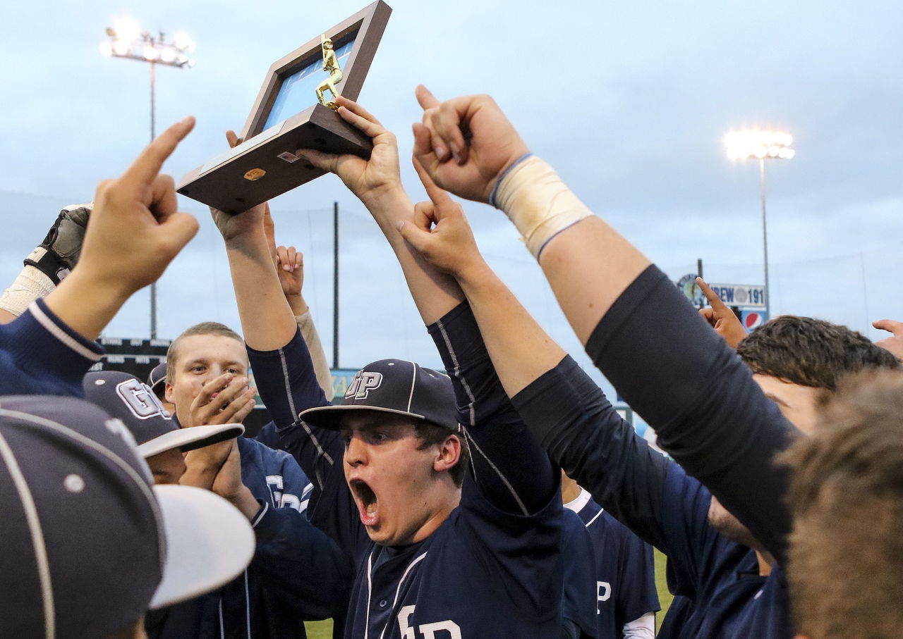 Glacier Peak’s Cole Walchenbach raises the 3A District 1 championship trophy Monday night at Everett Memorial Stadium after the Grizzlies defeated Lynnwood 5-4 in eight innings.