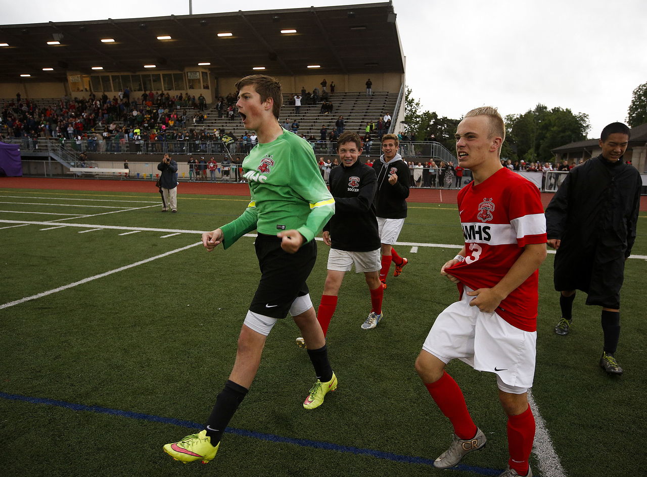 Archbishop Murphy goalkeeper Daniel Mycroft (left) celebrates after making the winning save in the shootout round against Quincy in the 2A state championship game Saturday at Sunset Chev Stadium in Sumner.