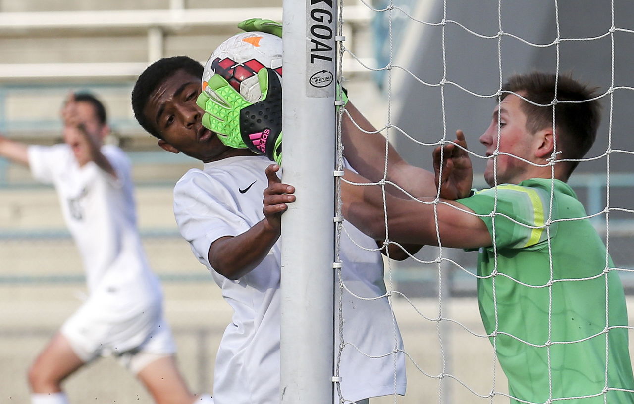 Garfield goalkeeper Sten Tolgu (right) tries but fails to stop a shot from Edmonds Woodway’s Kyle Aure (far left) with the Warriors’ Armon Tenaw closing in during a 3A state tournament match Friday night at Edmonds Stadium.