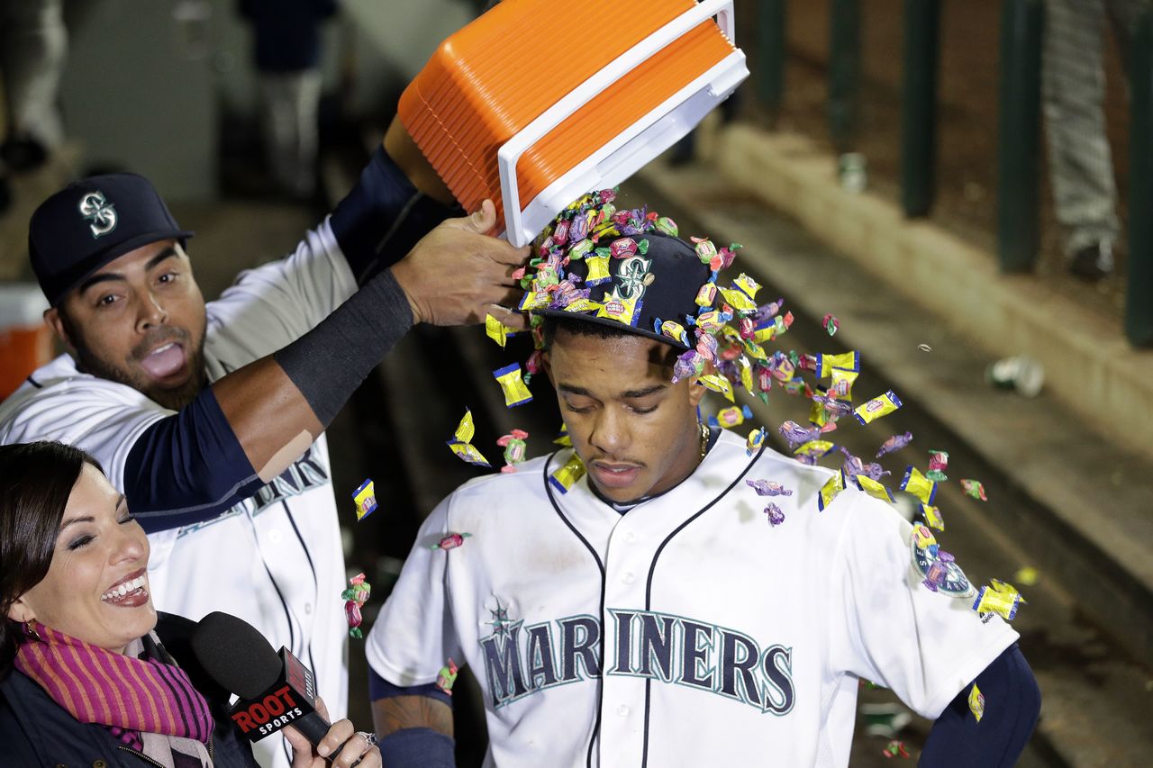 The Mariners’ Ketel Marte gets a shower of bubble gum from Nelson Cruz as Marte is interviewed after Seattle beat the Tampa Bay Rays 5-2 on Monday night.