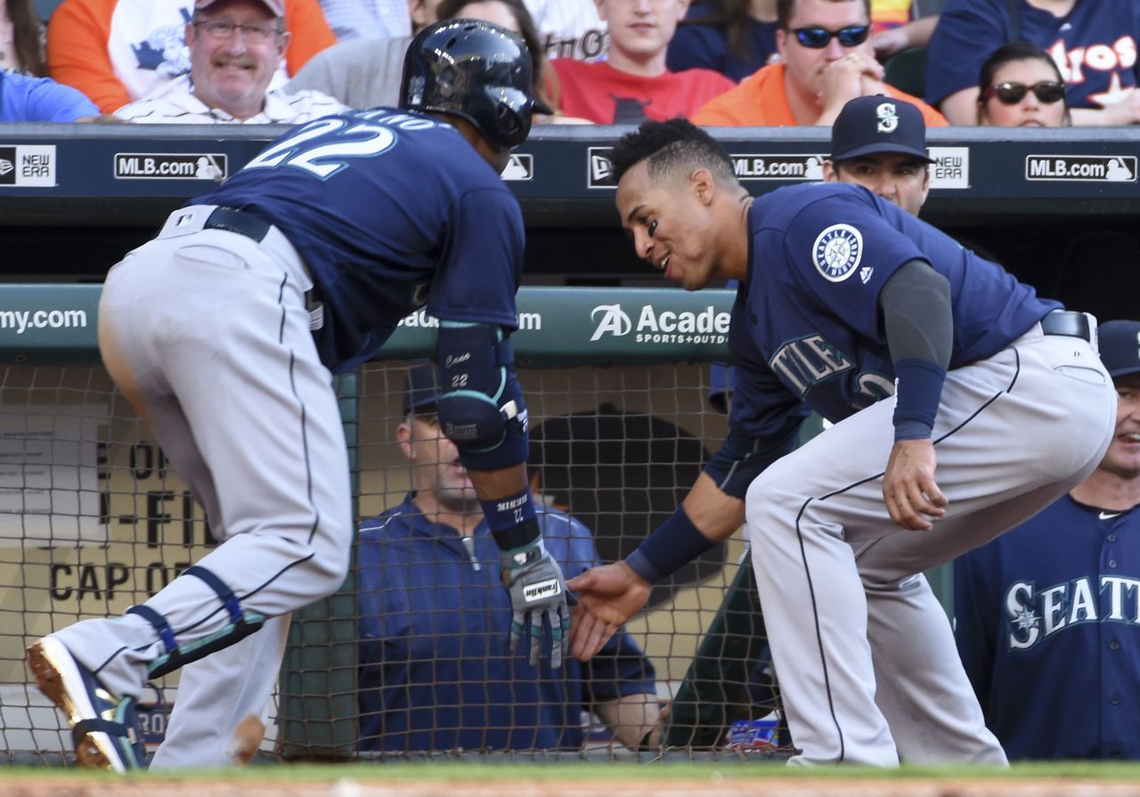 The Mariners’ Robinson Cano (left) celebrates his solo home run with Leonys Martin in the third inning of Saturday’s game.