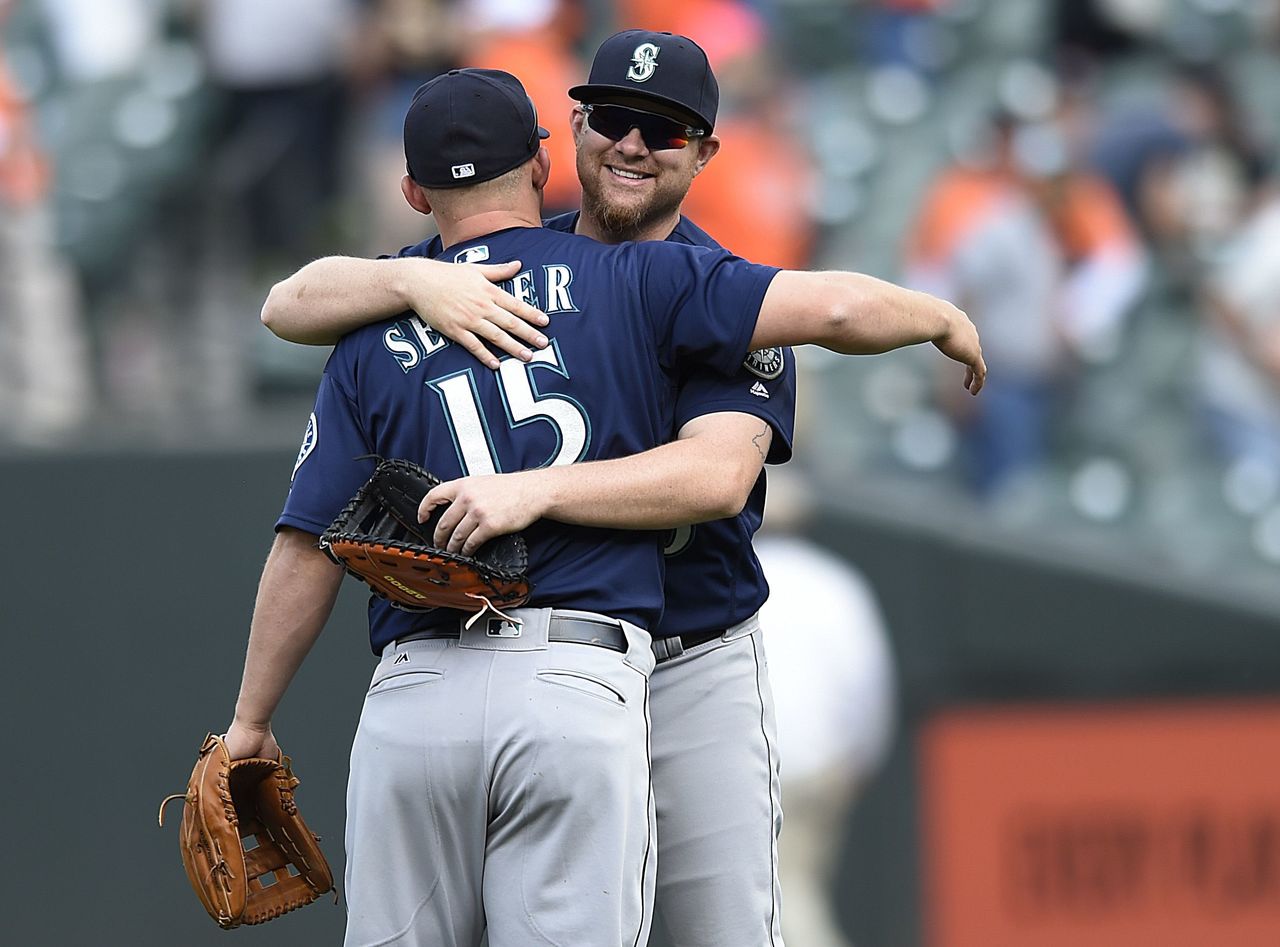 The Mariners’ Adam Lind (rear) and Kyle Seager celebrate their 7-2 win over the Orioles on Thursday in Baltimore.