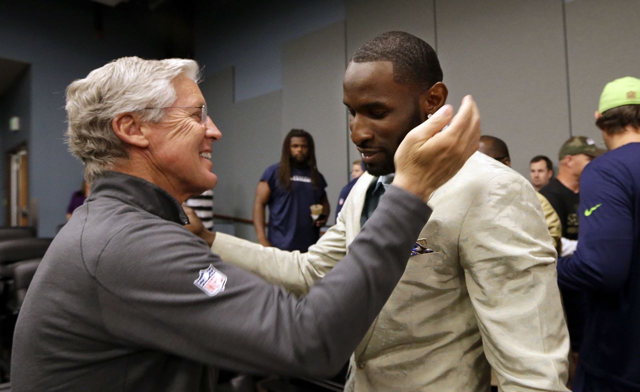 Former Seahawks wide receiver Ricardo Lockette (right) is embraced by head coach Pete Carroll after a news conference where Lockette announced his retirement at the team’s training facility Thursday in Renton.