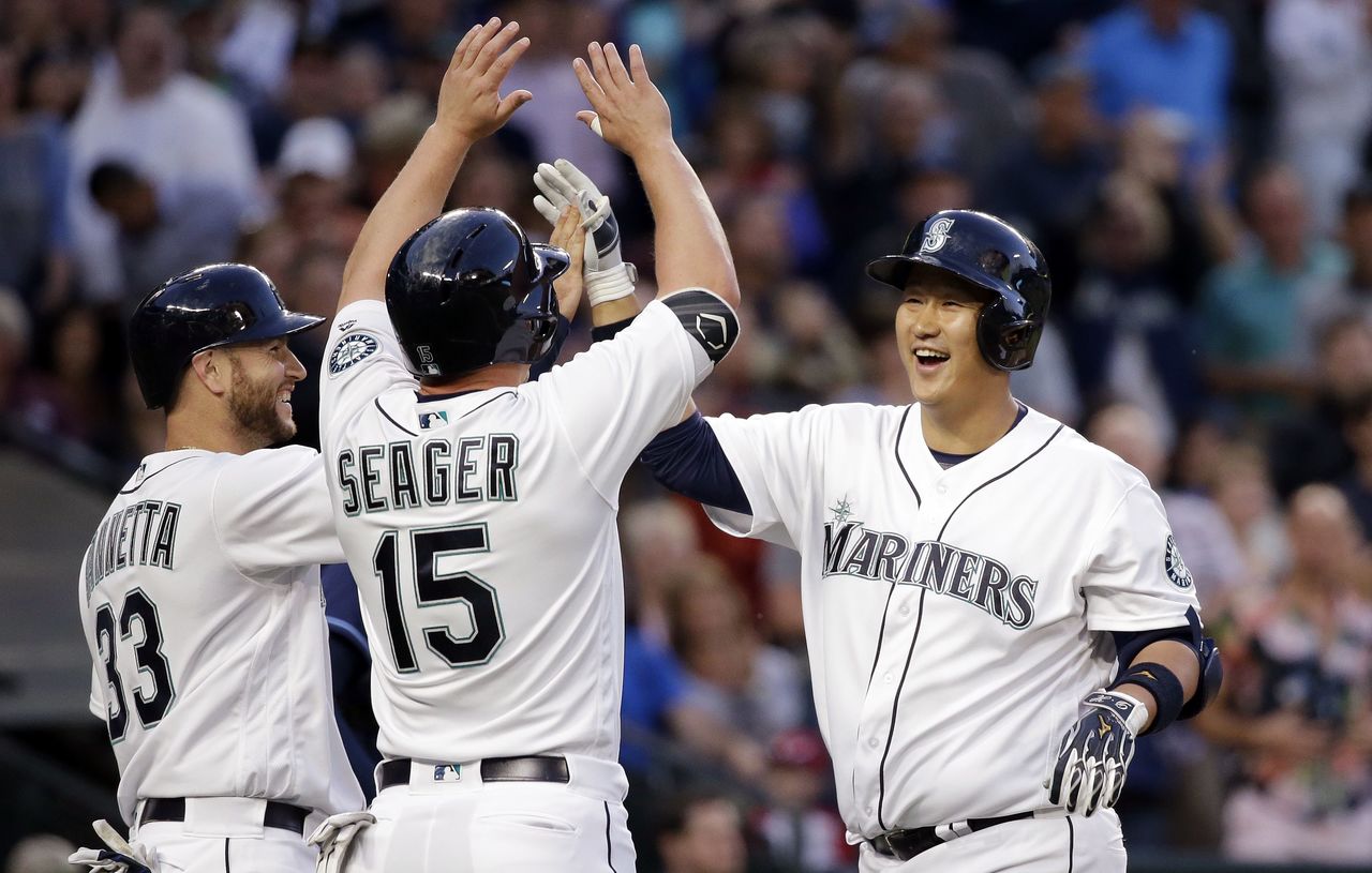 The Mariners’ Dae-Ho Lee (right) is met at home by Chris Iannetta (33) and Kyle Seager (15) after his three-run home run against the Rays in the fourth inning of a game Tuesday in Seattle.