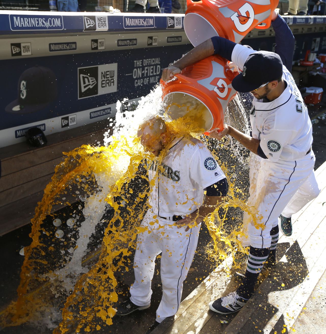 The Mariners’ Chris Iannetta is doused by teammates Steve Cishek (right) and Charlie Furbush (obscured) during a TV interview after Iannetta hit a walk-off solo home run during the 11th inning to lift Seattle to a 6-5 victory over the Rays.