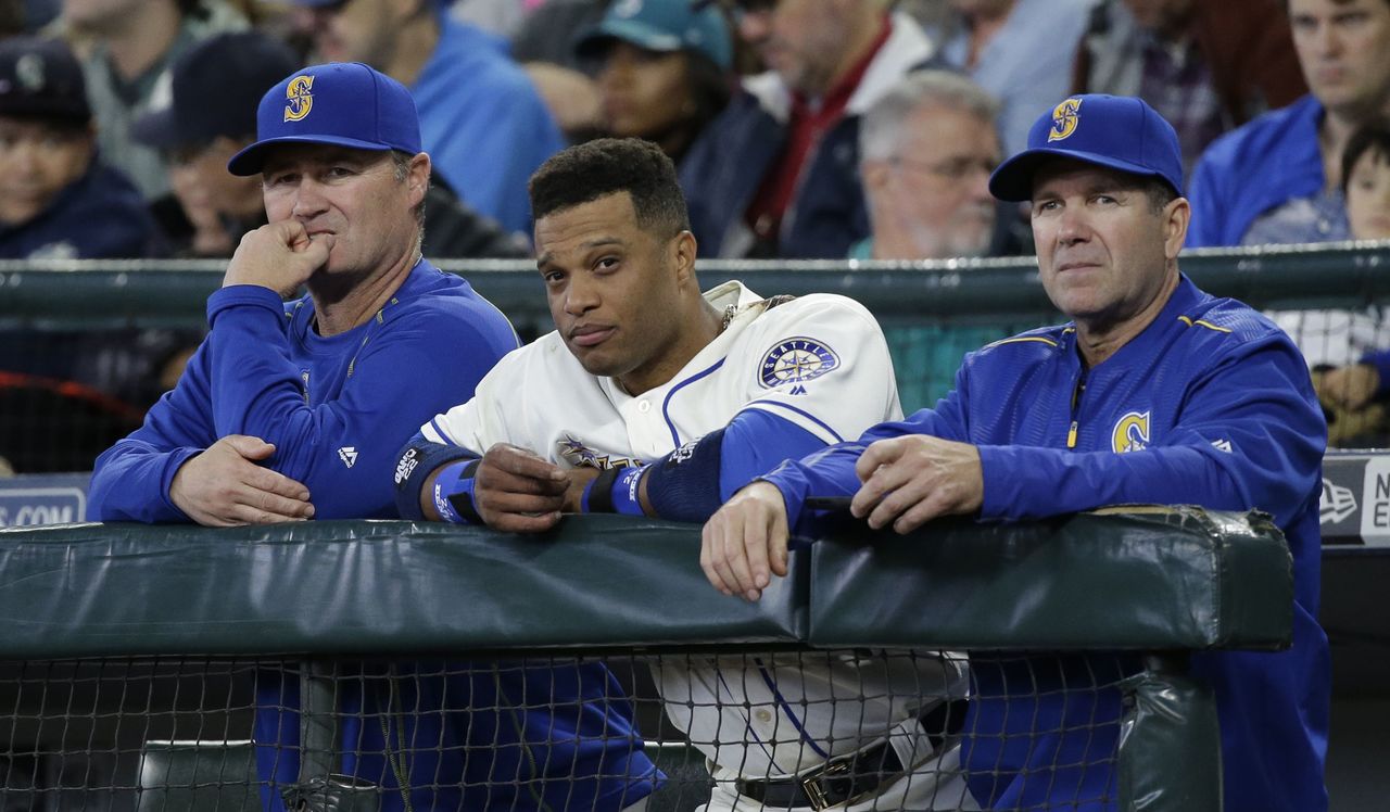 Mariners manager Scott Servais (left), second baseman Robinson Cano (center) and hitting coach Edgar Martinez look on during Sunday’s game against the Minnesota Twins.