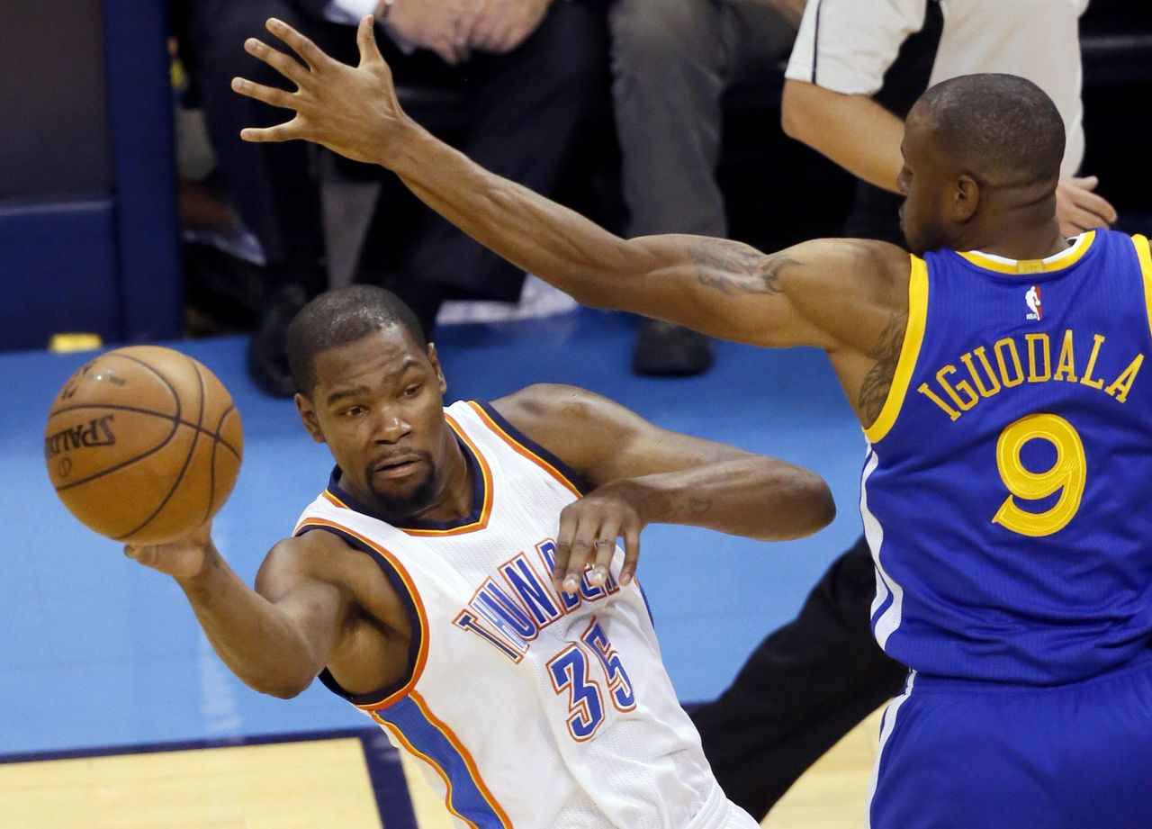 The Thunder’s Kevin Durant (35) passes the ball around the Warriors’ Andre Iguodala (9) during the first half in Game 4 on Tuesday.