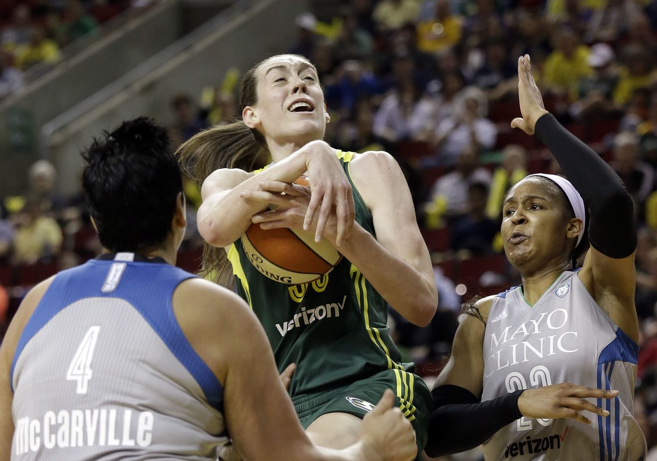 The Storm’s Breanna Stewart tries to drive between the Lynx’s Janel McCarville (4) and Maya Moore in the first half of Sunday’s game.