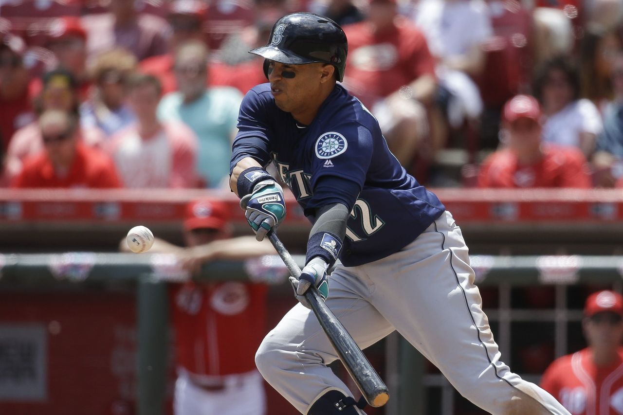 Mariners center fielder Leonys Martin bunts for a base hit in the fifth inning of Sunday’s game against the Reds. Martin had four hits in Seattle’s 5-4 victory.