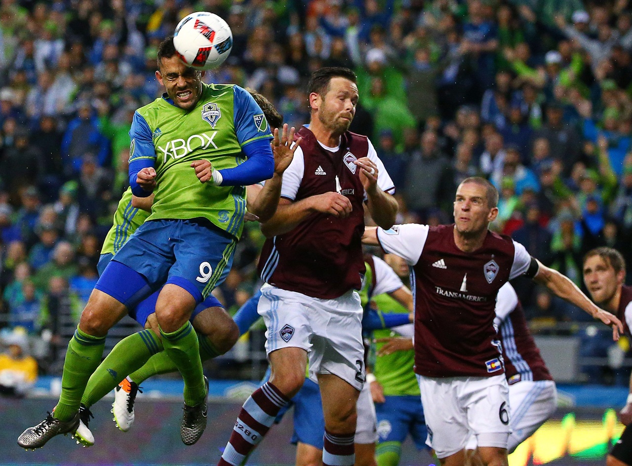 The Sounders’ Herculez Gomez (left) beats the Rapids’ Bobby Burling to the ball during Saturday night’s game.