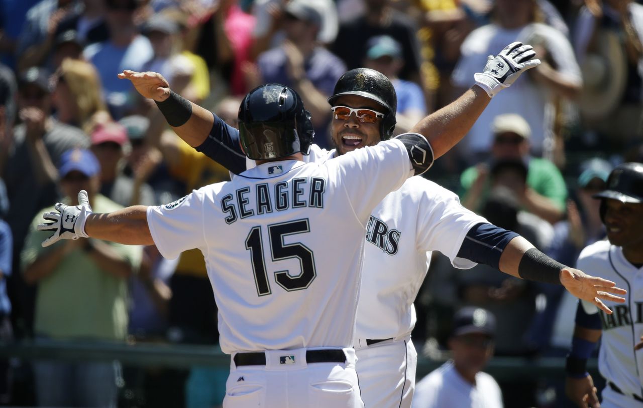 The Mariners’ Kyle Seager is greeted by Nelson Cruz at home plate after Seager hit a three-run home run in the second inning of Tuesday’s game against the San Diego Padres.